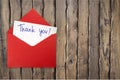 Thank you card and envelope on wooden background