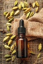 cardamom essential oil on burlap background