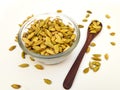 Cardamom pods in glass bowl with wooden spoon on white background Royalty Free Stock Photo