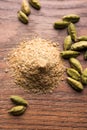 Cardamom powder or elaichi powder in bowl over moody background with pods. Royalty Free Stock Photo