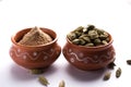 Cardamom powder or elaichi powder in bowl over moody background with pods. Royalty Free Stock Photo