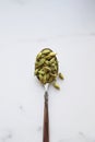 Cardamom seeds in spoon. Green and healthy spice concept. Seasoning for food and drinks