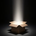 A cardboard box is centrally placed in a dark setting. Its flaps are open, and a bright ligh Royalty Free Stock Photo