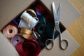Cardboard box full of equipment for sewing, stitching and for decorating of gifts and presents