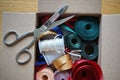 Cardboard box full of equipment for sewing, stitching and for decorating of gifts and presents