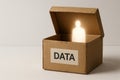 A cardboard box with the inscription DATA and a luminous figure inside. Space for text. Royalty Free Stock Photo