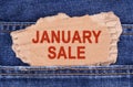 A cardboard box with the inscription- JANUARY SALE sticks out of jeans