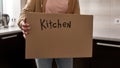 Cardboard box with kitchen things in woman hands