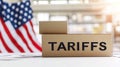 Cardboard box labeled tariffs in front of American flag Royalty Free Stock Photo