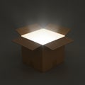 A cardboard box sits open in a dimly lit space, with bright light emitting from its Royalty Free Stock Photo