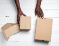 A woman with empty cardboard boxes on a white wooden background. Creating a model Royalty Free Stock Photo