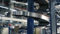 Cardboard boxes on conveyor belt in factory. Clip. Production line on which the boxes move in a spiral Royalty Free Stock Photo