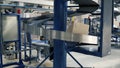 Cardboard boxes on conveyor belt in factory. Clip. Production line on which the boxes move in a spiral Royalty Free Stock Photo