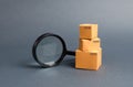 Cardboard boxes and a magnifying glass. Warehouse of finished products and equipment. buying and selling goods and services