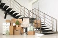 Cardboard boxes and packed chair near stairs in office. Moving day