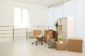 Cardboard boxes with packed stuff in new office, space for text. Moving day Royalty Free Stock Photo