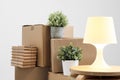 Cardboard boxes with things are stacked on the floor against the background of a white wall close up. Books and table Royalty Free Stock Photo