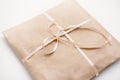 Cardboard carton package wrapped with light brown paper and tied with pink string ribbon in bow Royalty Free Stock Photo