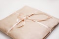 Cardboard carton package wrapped with light brown paper and tied with pink string ribbon in bow Royalty Free Stock Photo