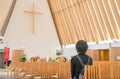 Christchurch, New Zealand -October-01-2017 : Woman praying to god inside of Cardboard Cathedral in Christchurch, New Zealand. Royalty Free Stock Photo