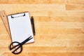 Cardboard clipboard, scissors, ruler and pen on wooden background