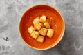 Cardboard cup of refreshing tomato soup gazpacho with croutons and dried herbs on gray background Royalty Free Stock Photo