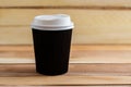 Cardboard disposable cups isolated on a wooden background. Front view Royalty Free Stock Photo