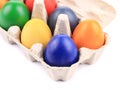 Cardboard egg box with Easter colored eggs. Royalty Free Stock Photo