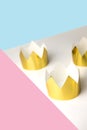 Cardboard golden crowns lying on a white table. Minimalistic style. Place for text. Copyspace.