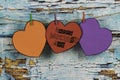 Cardboard hearts hung with tweezers to congratulate Mother`s Day  Multi-colored hearts on weathered blue wooden background vintag Royalty Free Stock Photo