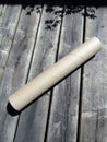 Cardboard mailing tube with plastic end caps placed on patio deck