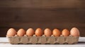 Cardboard package container of fresh brown eggs on rustic wooden table