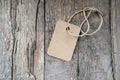 Cardboard price tag or blank tag for your label lying on the weathered wooden background