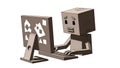 Cardboard Robot Character Working on Computer with Sad Expression Royalty Free Stock Photo