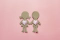 Cardboard silhouettes girl and boy with hearts on pink background. Top view.