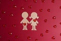 Cardboard silhouettes girl and boy with hearts on a red background