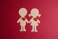 Cardboard silhouettes girl and boy with hearts on a red background. St. Valentines Day.