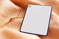 Cardboard tag with space for text on pale orange fabric, closeup Royalty Free Stock Photo