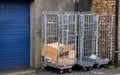 Cardboard trash collected in trolley roll cage at the back of a shop delivery area