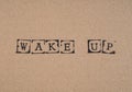 Cardboard with words Wake Up made by black alphabet stamps