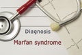 Cardiac diagnosis of Marfan Syndrome. On doctor workplace are red stethoscope, printed on paper ECG line and a pen close up lying Royalty Free Stock Photo