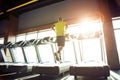 Cardio workout. Rear view of a mature athletic man in sportswear running on a treadmill in a gym, full length Royalty Free Stock Photo