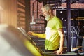 Cardio workout. Side view of a happy middle aged athletic man in sportswear adjusting speed on a treadmill while