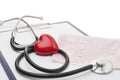 Cardiogram with stethoscope and red heart on table