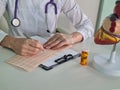 Cardiologist examines a cardiogram against background of artificial heart model