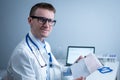 Cardiologist reading an ECG print-out. Doctor analyzing electrocardiogram. Practitioner examine patient test results