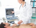 Cardiologist using sonogram on male patient