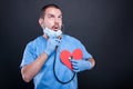 Cardiologist using stethoscope on red shape heart Royalty Free Stock Photo