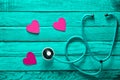 Cardiology equipment. Listen to your heart. The concept of care for the heart. Stethoscope, hearts on a turquoise wooden surface. Royalty Free Stock Photo