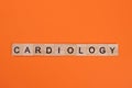 Cardiology word from wooden letters on orange background